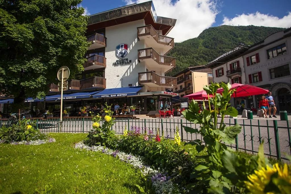 Hotel Bar Bistro Pointe Isabelle in a mountain town with flowers and green slopes.