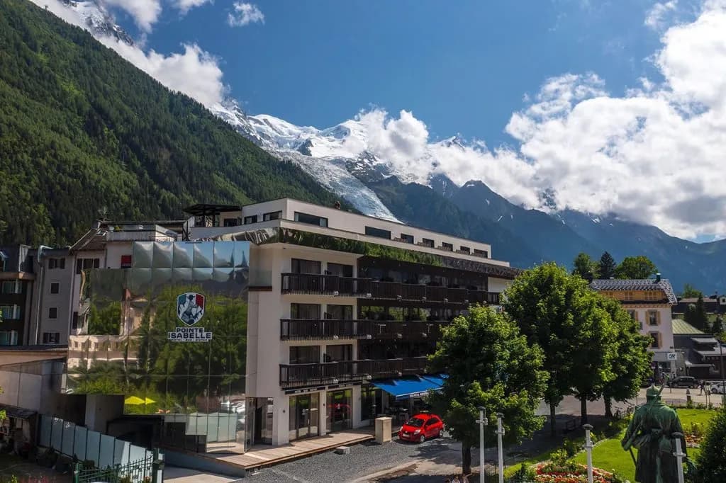 Hotel Pointe Isabelle with snow-capped mountains and forest in Chamonix valley